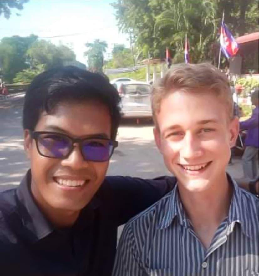 Two smiling men posing together outdoors